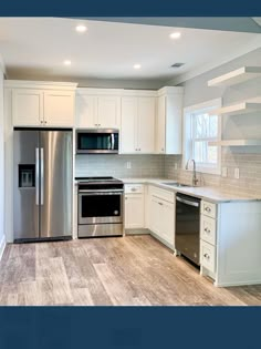 an empty kitchen with stainless steel appliances and white cabinetry, including a dishwasher