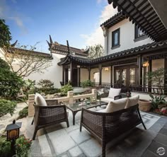 an outdoor patio with wicker furniture and potted plants