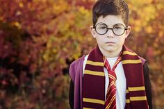 a young boy wearing glasses and a harry potter scarf