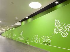 an empty hallway with green walls and white lettering on the wall that says aona