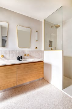 a bathroom with two sinks and mirrors on the wall