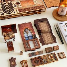 an assortment of miniature furniture and accessories on a white table with a bottle of wine