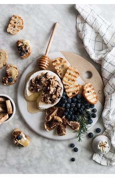 a white plate topped with blueberries and waffles next to other food items