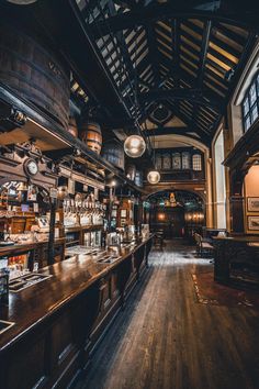 an old fashioned bar with lots of bottles on the shelves and lights hanging from the ceiling