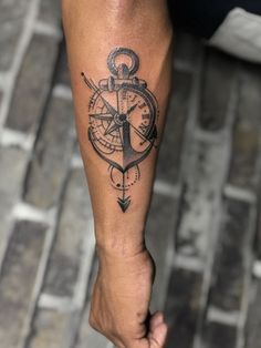 a man with a compass tattoo on his arm