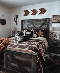 a dog laying on top of a bed in a bedroom next to two wooden arrows