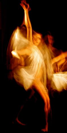 blurry photograph of dancers in motion on black background