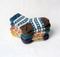 a stack of multicolored knitted mittens sitting on top of each other