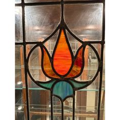 a stained glass window with an orange flower on it