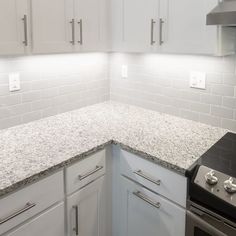 an empty kitchen with white cabinets and granite counter tops on the counters is pictured in this image