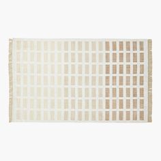 a beige and white rug with squares on the bottom, in front of a white background