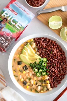 a bowl filled with beans, rice and avocado next to a bag of rice