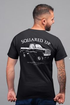 a man wearing a black t - shirt with the words squared up printed on it