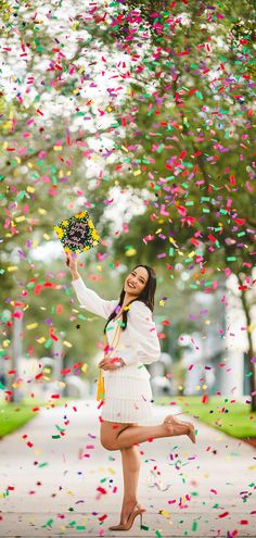 a woman is posing with confetti in her hand