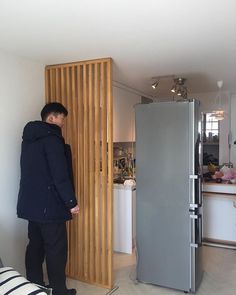 a man standing next to a refrigerator in a kitchen