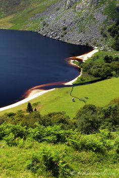 a large body of water surrounded by lush green hills