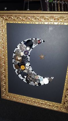 a gold frame with a moon made out of buttons