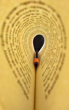 an open book with a pencil in the middle