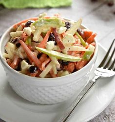 a salad with carrots, celery and black beans in a white bowl