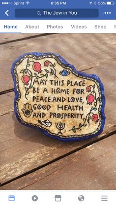 a wooden table topped with a blue and white sign that says, may this place be a home for peace and love good health and prosperity