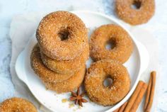 cinnamon sugar donuts on a white plate with cinnamon sticks and star anise sprinkles