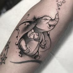 an elephant tattoo on the arm with stars around it and water splashing from its trunk