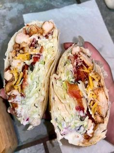 two tacos with meat, cheese and other toppings are held in someone's hand