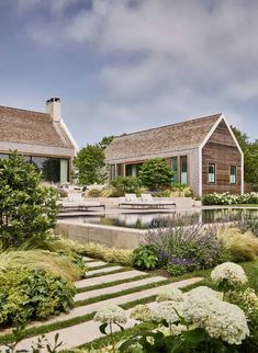 two wooden houses sitting on top of a lush green hillside next to a pool and garden