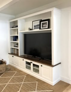 a living room with white bookcases and a flat screen tv