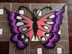 a cross stitch butterfly sitting on top of a table