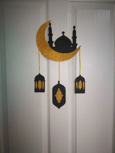 the door is decorated with gold glitter and black decorations, including an islamic crescent hanging from it's side