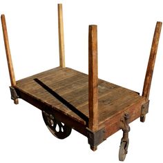 an old wooden cart with four posts on the front and two wheels attached to it