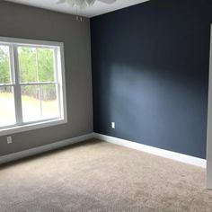 an empty room with blue walls and white ceiling fan in the corner on the far wall