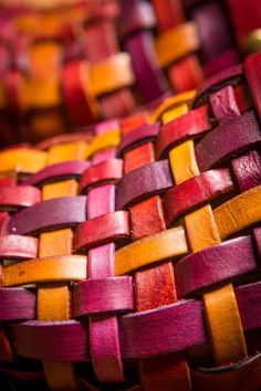 a close up view of a woven basket with red and yellow strips on the sides