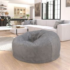 a living room filled with furniture and a large bean bag chair on top of a hard wood floor