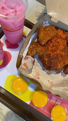 fried chicken and two drinks are on the table next to each other, including one pink drink