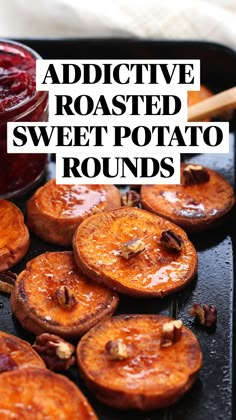 baked sweet potatoes with cranberry sauce and pecans on a baking sheet next to a wooden spoon