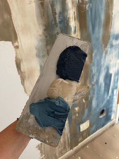 a person is holding up some paint in their hand