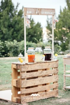 an outdoor bar made out of wooden pallets with drinks on the table and jars