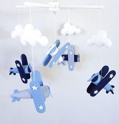 an airplane mobile is hanging from the ceiling with clouds and stars on it's sides