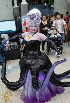 a woman dressed in black and purple sitting on top of an octopus