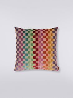 a multicolored pillow sitting on top of a white wall