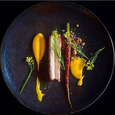 a black plate topped with different types of food