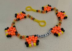 an orange and black beaded necklace with scissors