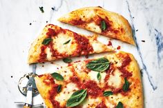 three slices of pizza with basil and cheese on them, sitting on a marble surface