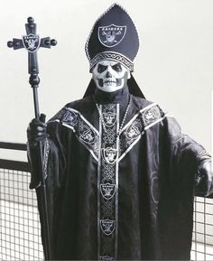 a statue of a skeleton wearing a black robe and holding a cross in his hand