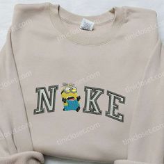 The Nike x Dave Minion Embroidered Hoodie is a must-have for any Minion lover! Made with high-quality materials, this hoodie features intricate embroidery of Dave, one of your favorite Minions. Stay cozy and stylish with this unique and playful hoodie. Perfect for casual outings or lounging at home, it offers comfort and versatility. Stand out from the crowd and showcase your love for Minions with this exclusive collaboration. Get yours now and add a touch of fun to your wardrobe! The Minion Emb Kevin Minion, Nike Cartoon, Nike Inspired, Maroon Hoodie, Cute Nike Outfits, Embroidered Shirts, Custom Nike, Shirt Nike, Volley Ball