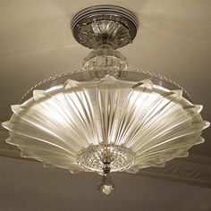 a glass light fixture hanging from the ceiling in a room with white walls and ceilings