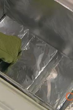 a piece of tin foil sitting on top of a metal pan covered in green cloth