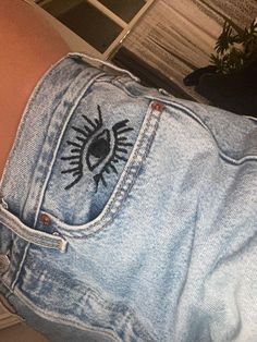 the back of someone's jean shorts with an eye drawn on it